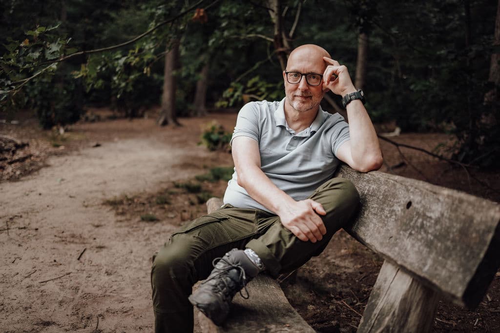 Jeroen van Pelt op een bankje in het bos